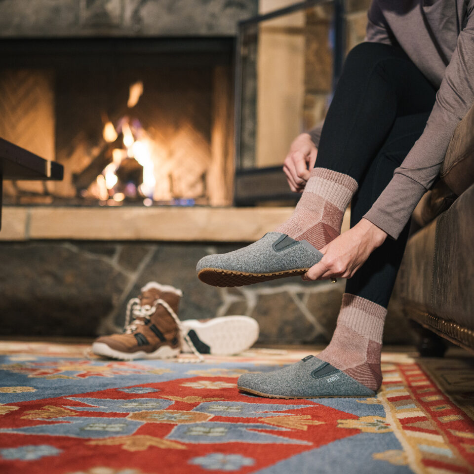 Papuci de casă barefoot Xero Shoes Pagosa pentru femei, slip-on ușori pentru vreme răcoroasă, cu exterior tip lână sintetică, călcâi pliabil, talpă FeelTrue™ de 4 mm și 136 g (37,5), susținuți de garanția de 8000 km (5,000 Mile Sole Warranty).